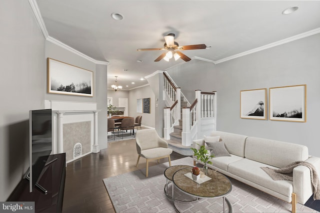 living room featuring ceiling fan with notable chandelier, crown molding, and wood-type flooring