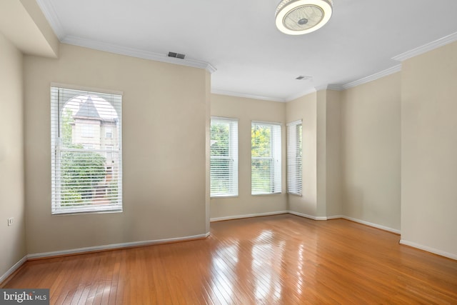 unfurnished room featuring a healthy amount of sunlight, light hardwood / wood-style floors, and crown molding