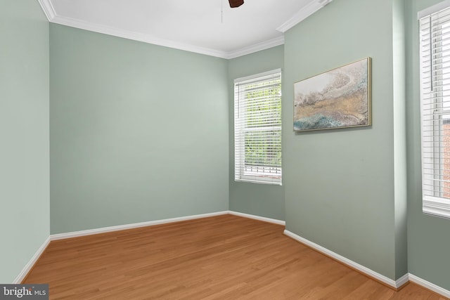 spare room with crown molding, a healthy amount of sunlight, and wood-type flooring