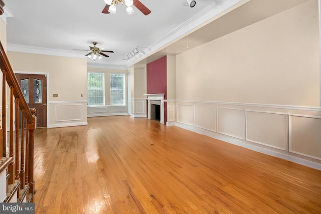 unfurnished living room featuring light hardwood / wood-style flooring, ceiling fan, and crown molding