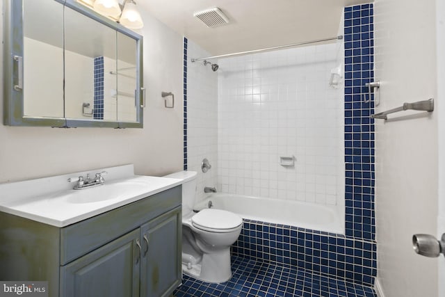 full bathroom featuring tile patterned floors, vanity, toilet, and tiled shower / bath