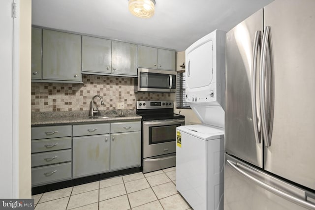 kitchen with sink, stainless steel appliances, backsplash, gray cabinets, and light tile patterned flooring