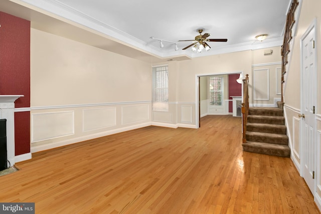 unfurnished living room with ceiling fan, crown molding, track lighting, and light hardwood / wood-style flooring