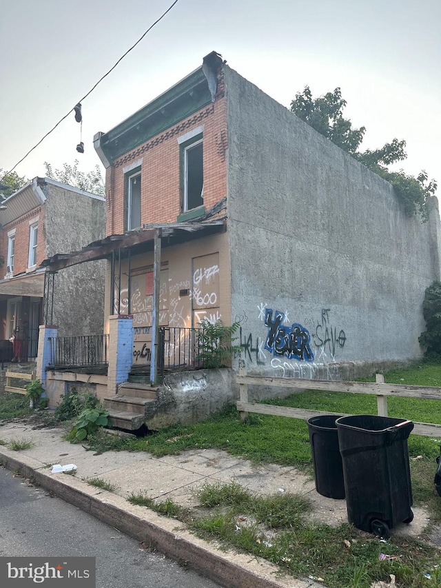 view of front facade with covered porch, stucco siding, and brick siding