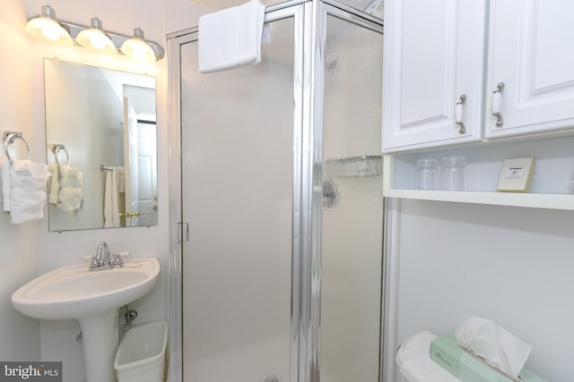 bathroom with an enclosed shower and toilet