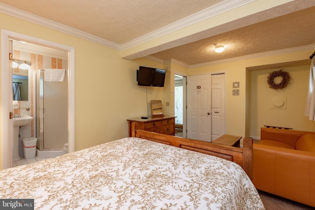 carpeted bedroom with a textured ceiling, ensuite bathroom, and crown molding