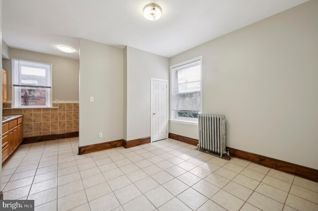 interior space featuring a wealth of natural light, radiator heating unit, and light tile patterned floors