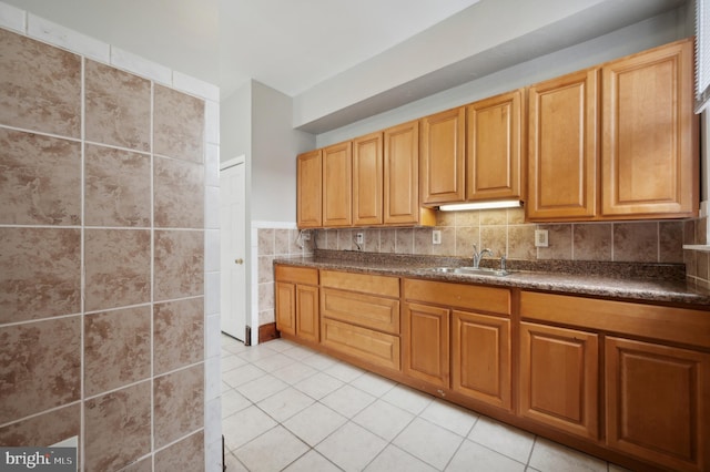 kitchen with tile walls, sink, and light tile patterned floors