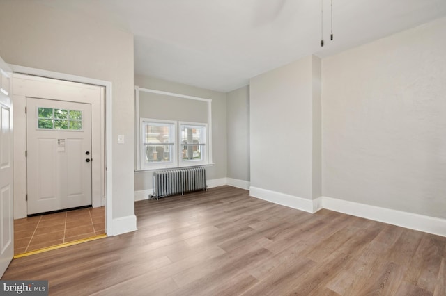 entryway with hardwood / wood-style floors and radiator