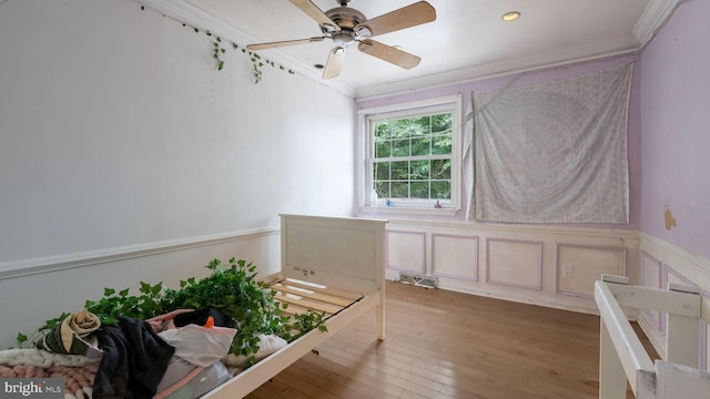 interior space with wood-type flooring, crown molding, and ceiling fan