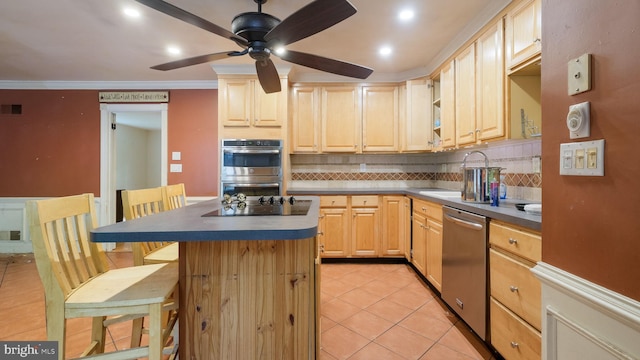 kitchen featuring a breakfast bar, a kitchen island, light brown cabinets, appliances with stainless steel finishes, and crown molding