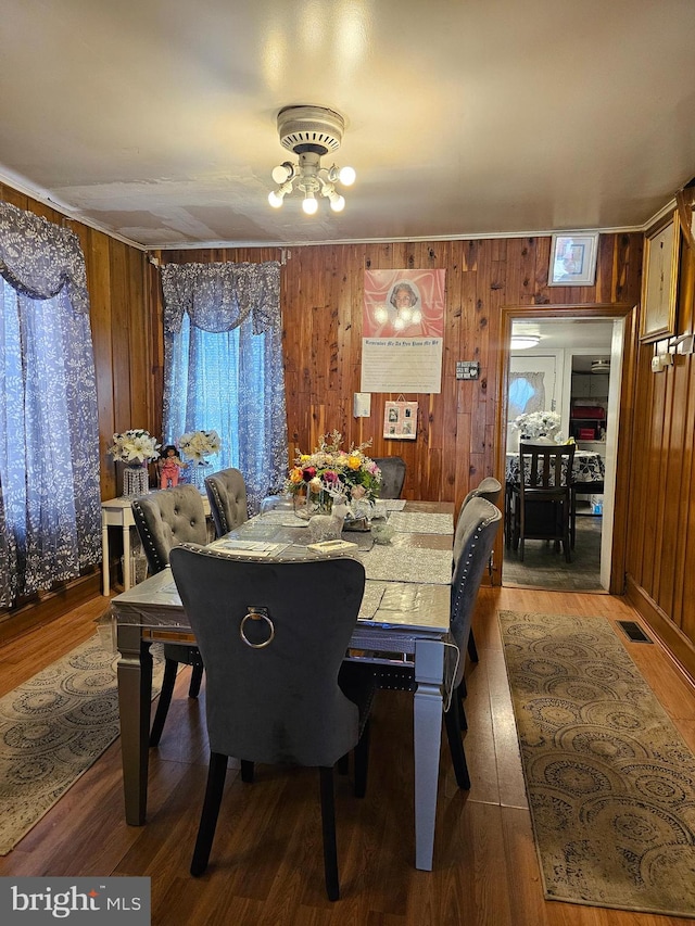 dining area featuring wooden walls and dark hardwood / wood-style floors