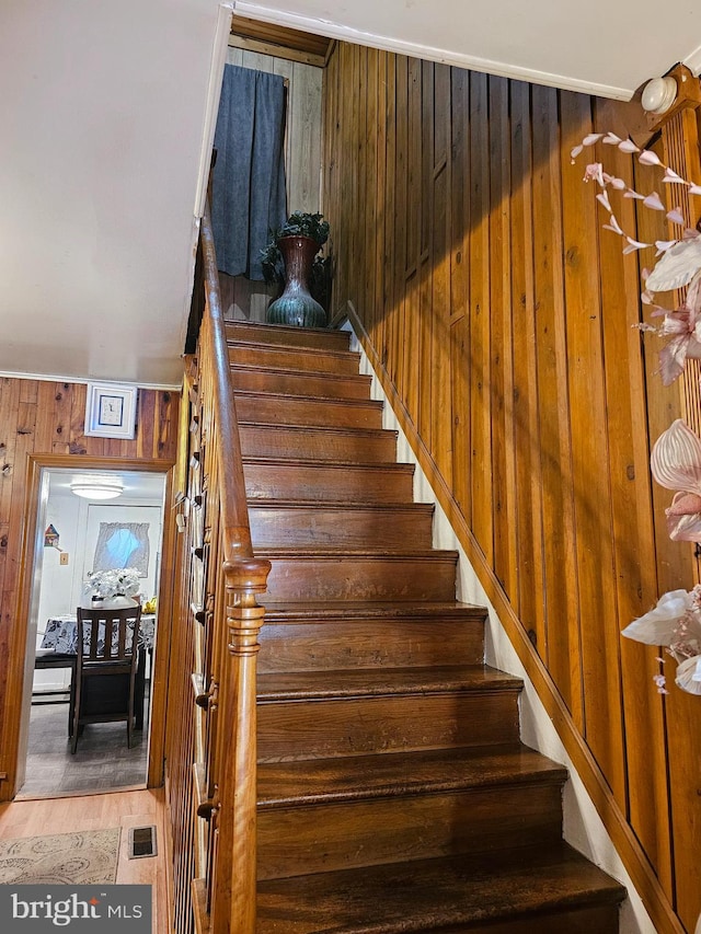 stairs featuring hardwood / wood-style flooring and wooden walls