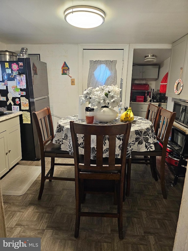 dining space featuring dark parquet floors