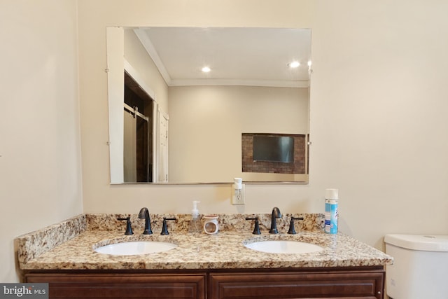 bathroom featuring ornamental molding, vanity, and toilet