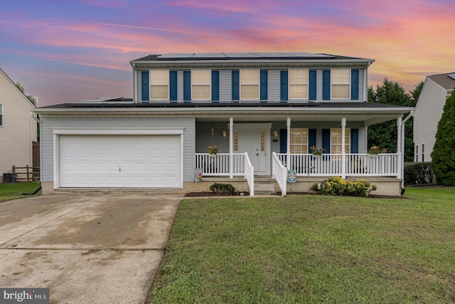 view of front of home featuring a lawn, a porch, and a garage