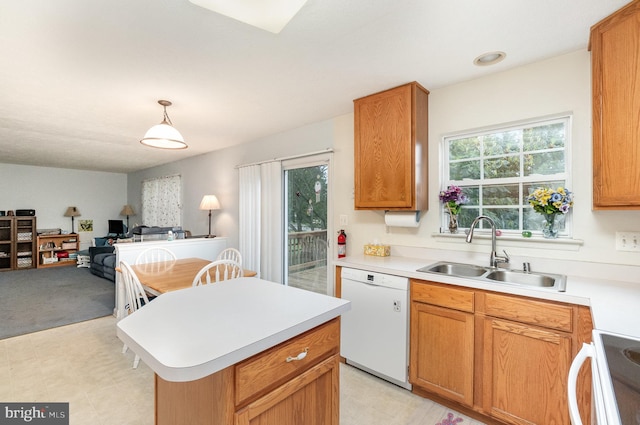 kitchen featuring pendant lighting, sink, range, dishwasher, and a center island