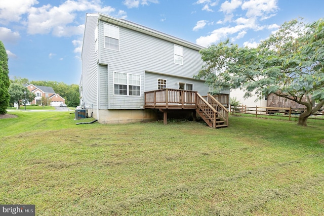 back of property featuring a wooden deck, central AC, and a yard