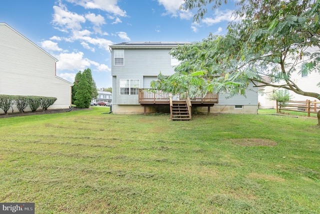 back of house featuring a wooden deck and a yard