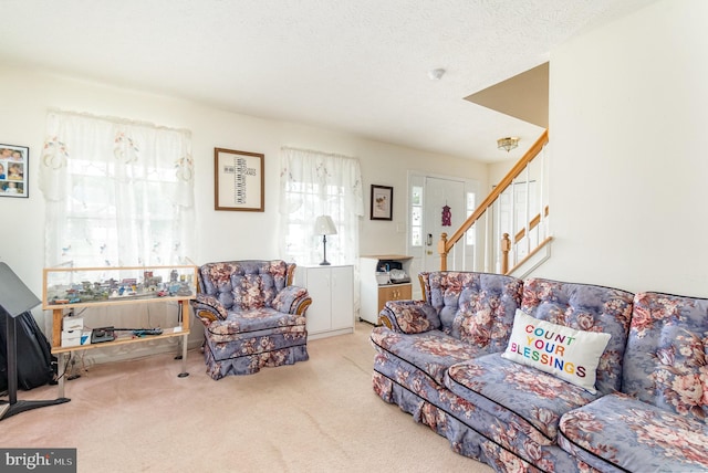 living room featuring light colored carpet and a textured ceiling