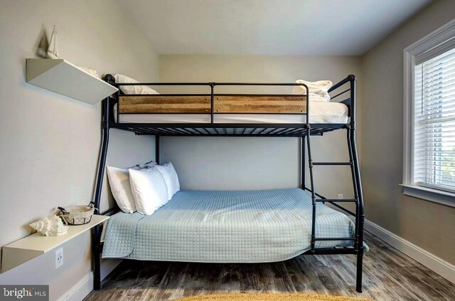 bedroom featuring multiple windows and dark wood-type flooring