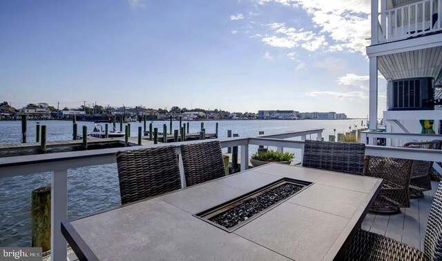 dock area featuring a water view, central air condition unit, and a fire pit