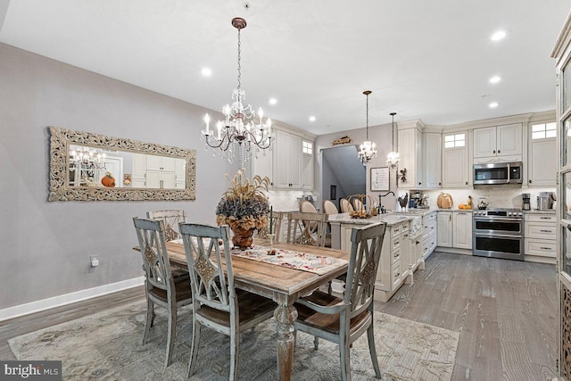 dining space with hardwood / wood-style flooring, sink, and a notable chandelier