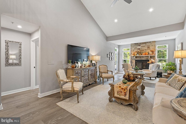 living room with ceiling fan, hardwood / wood-style flooring, a fireplace, and a healthy amount of sunlight