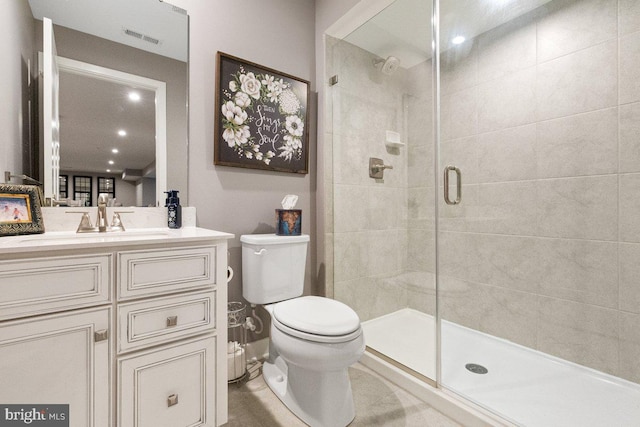 bathroom with vanity, toilet, and a shower with door