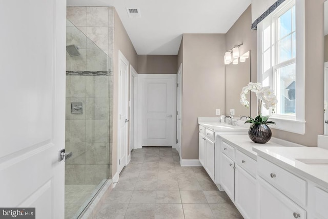 bathroom featuring tile patterned flooring, vanity, and a shower with shower door