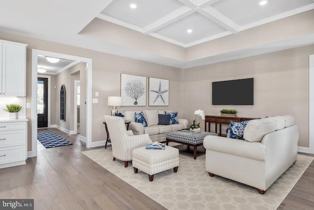 living room featuring beamed ceiling, light hardwood / wood-style floors, coffered ceiling, and crown molding