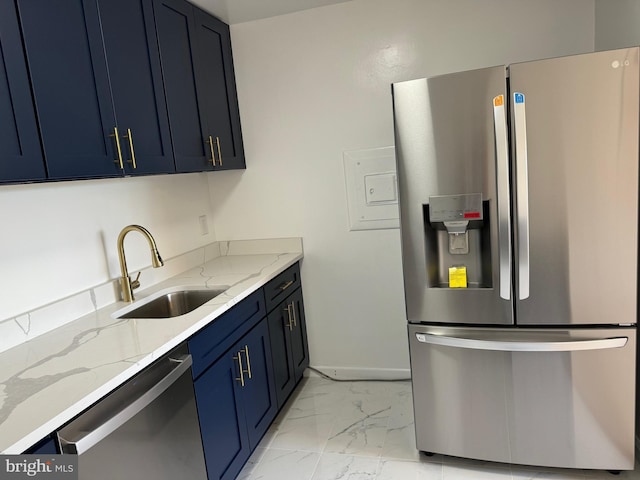 kitchen with appliances with stainless steel finishes, light stone countertops, blue cabinetry, and sink