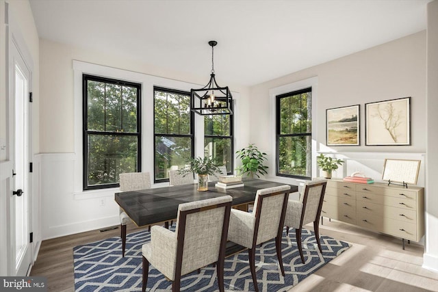 dining room with an inviting chandelier, dark hardwood / wood-style floors, and a healthy amount of sunlight