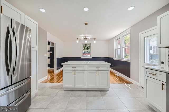 kitchen featuring white cabinetry, a chandelier, decorative light fixtures, and stainless steel fridge