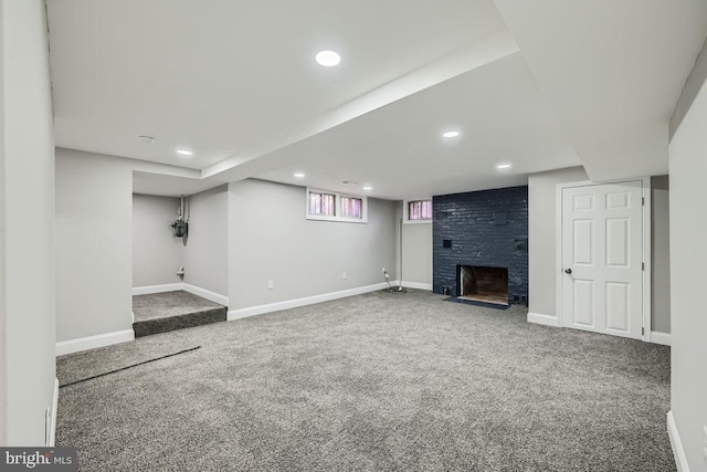 unfurnished living room featuring a large fireplace and carpet floors