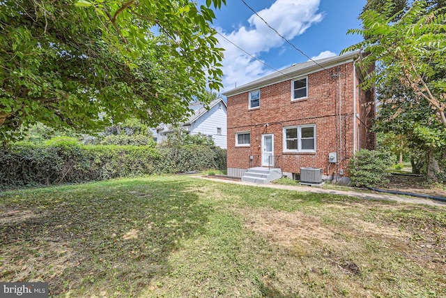 view of front of property with a front lawn and central AC