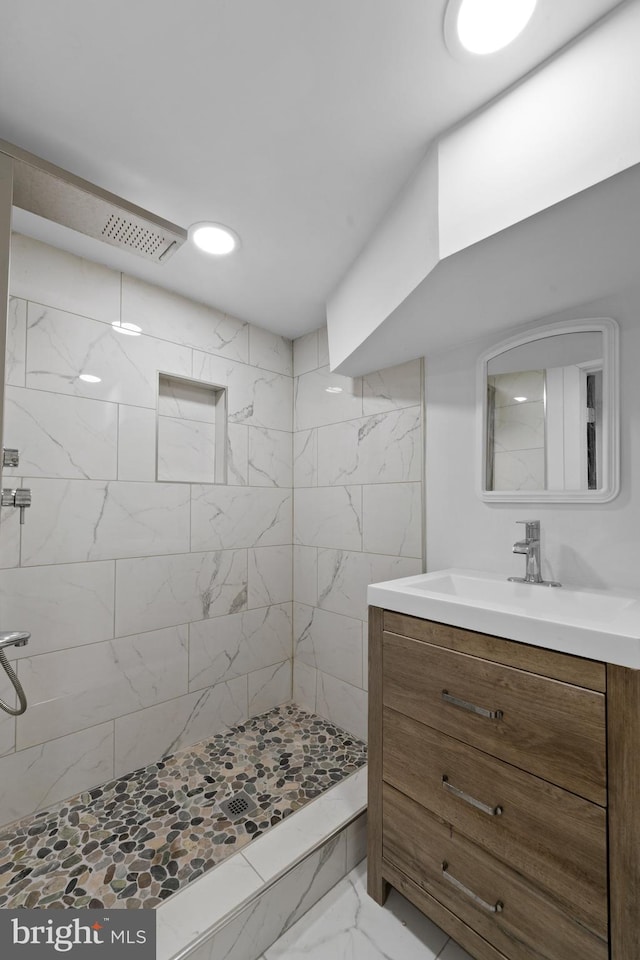 bathroom with vanity and a tile shower