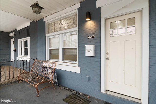 view of exterior entry featuring covered porch