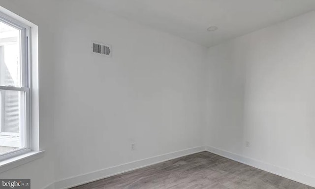 unfurnished room featuring a healthy amount of sunlight and hardwood / wood-style floors