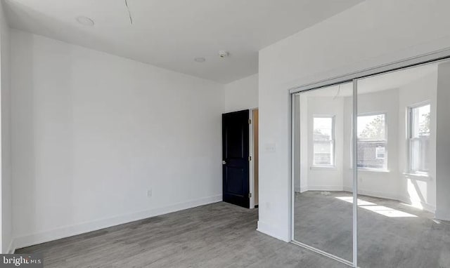 unfurnished bedroom featuring hardwood / wood-style flooring and a closet