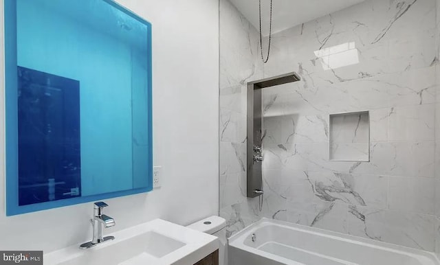 full bathroom featuring tiled shower / bath combo, vanity, and toilet