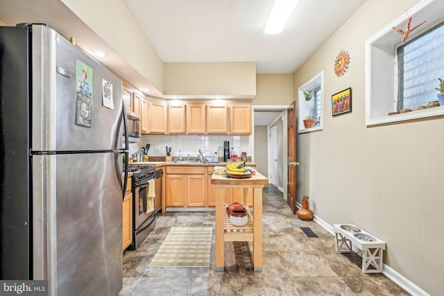 kitchen featuring light brown cabinetry, stainless steel appliances, sink, and tasteful backsplash