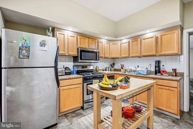 kitchen featuring light brown cabinets, appliances with stainless steel finishes, sink, and tasteful backsplash