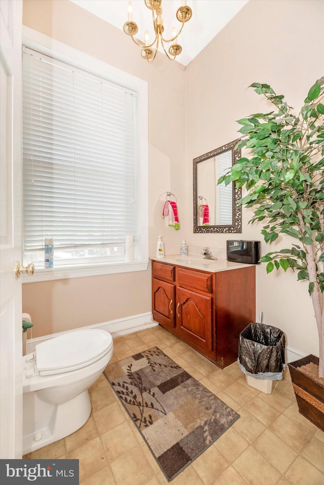 bathroom featuring a notable chandelier, vanity, toilet, and tile patterned floors