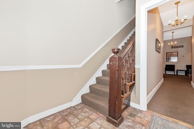 stairs with an inviting chandelier, high vaulted ceiling, carpet floors, and crown molding