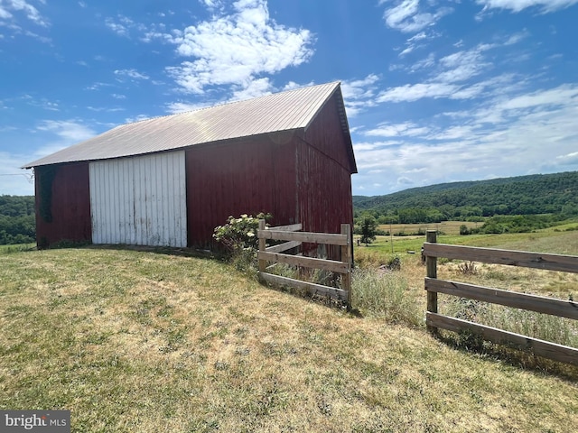 view of outbuilding with a lawn and a rural view