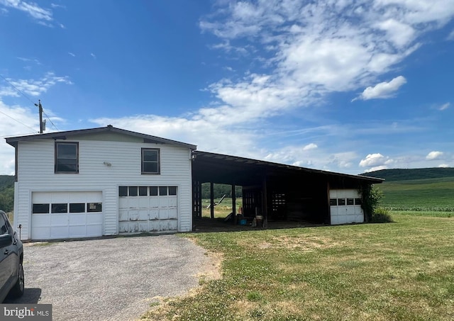 view of front of house with a carport, a garage, and a front yard