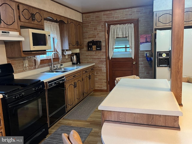 kitchen featuring black appliances, dark hardwood / wood-style floors, and sink