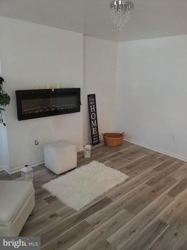 living room featuring an inviting chandelier, a fireplace, and hardwood / wood-style floors