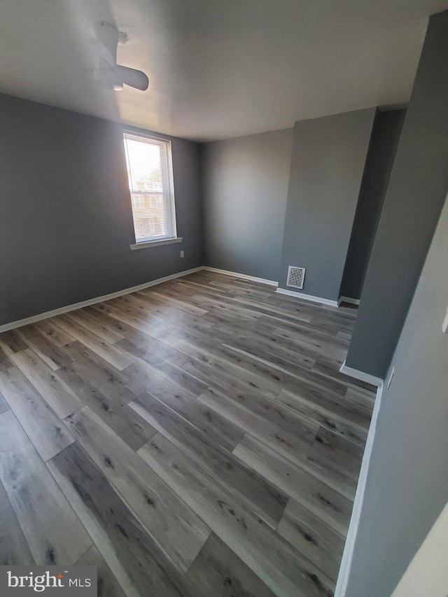 unfurnished room featuring ceiling fan and hardwood / wood-style flooring